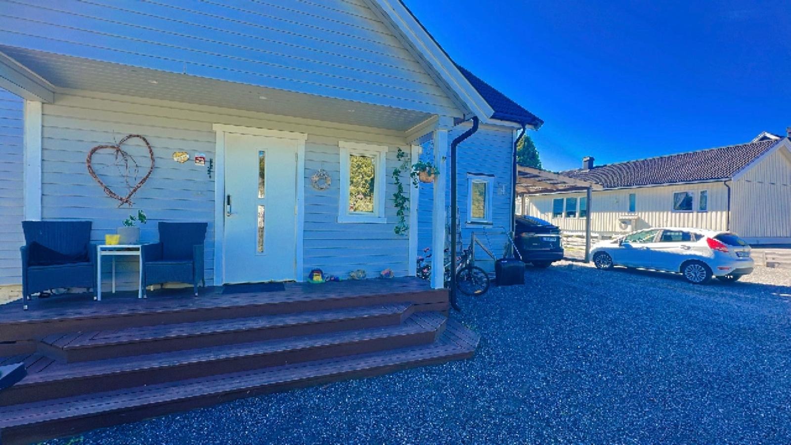 Inngangsparti med parkeringsplass og carport